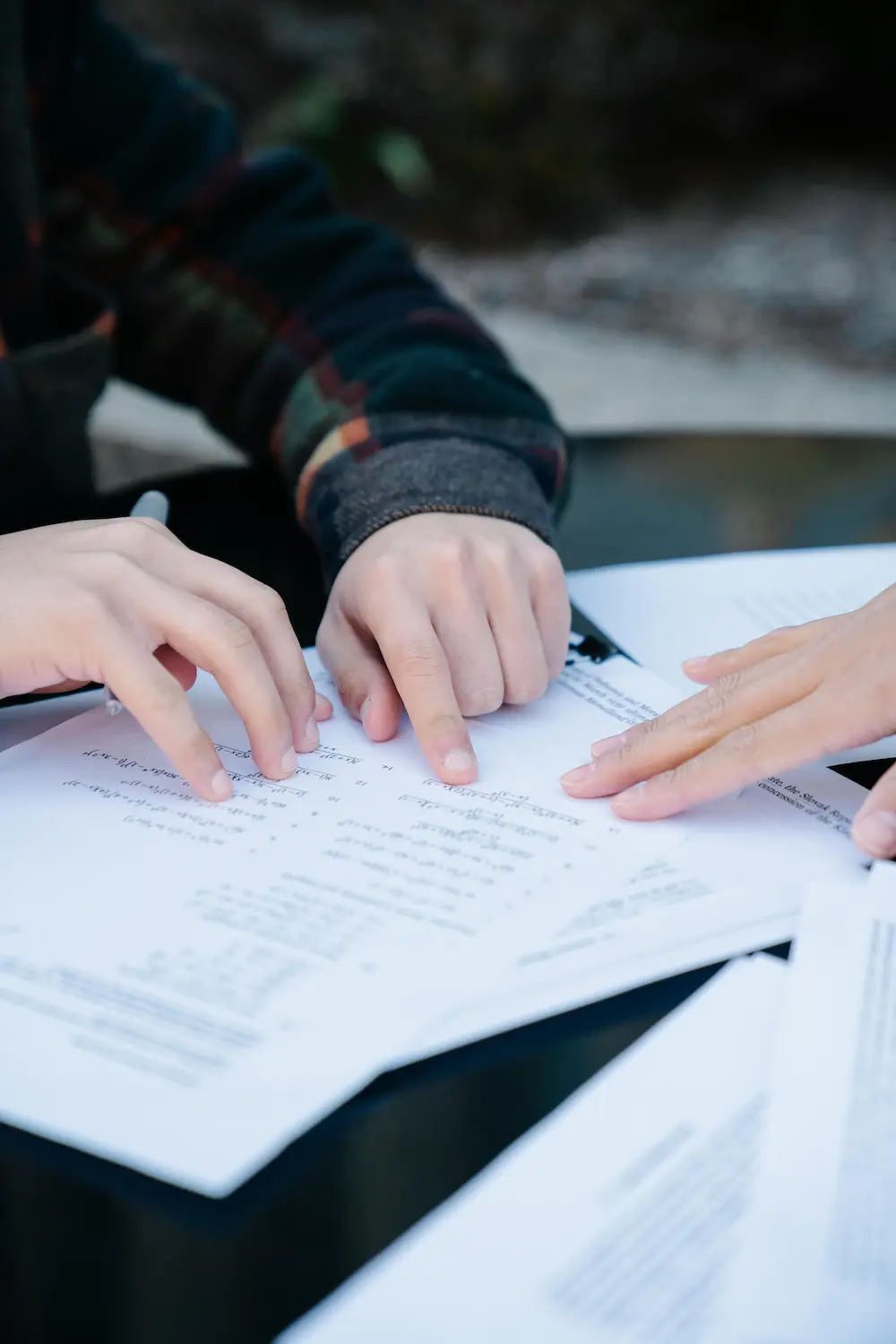 Close-up of a child's hands pointing to a homework on the table